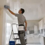 Tarif nettoyage plafond tendu : technicien nettoyant le plafond tendu